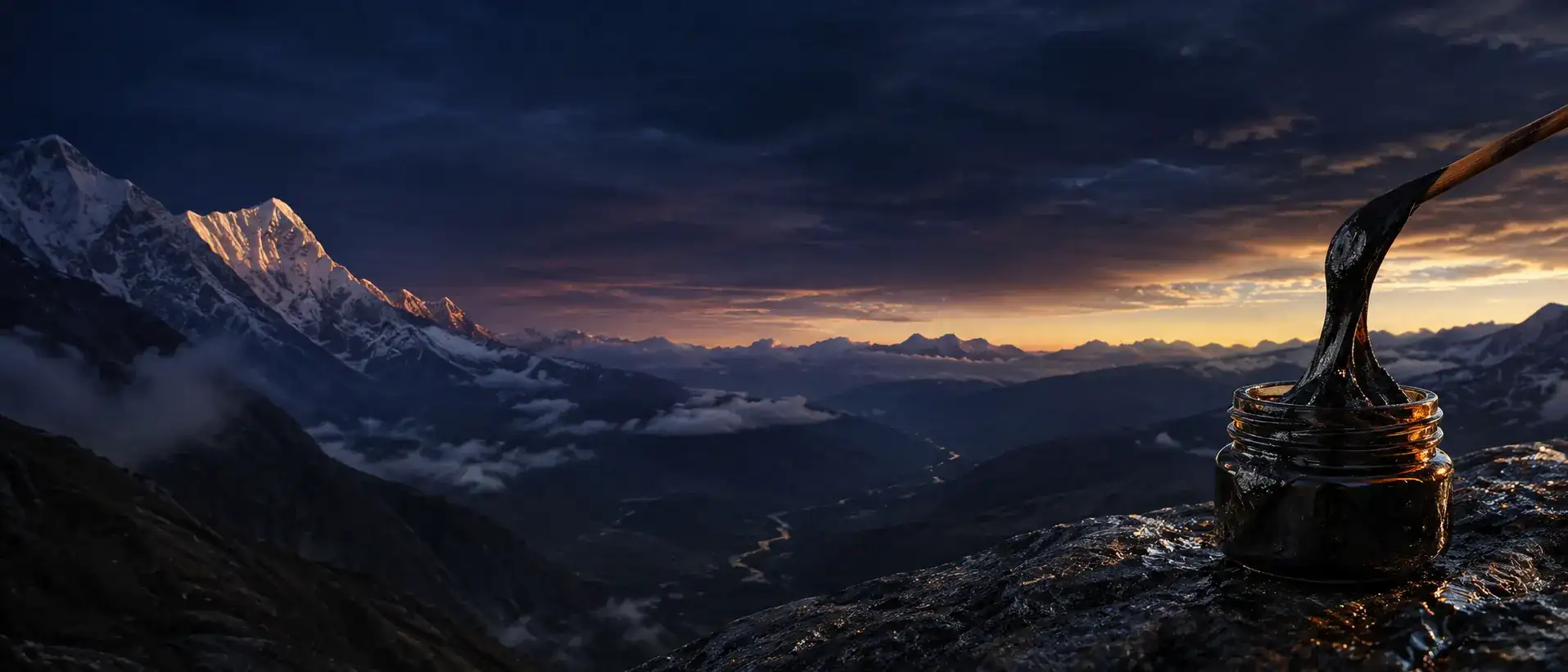 An amber jar of dark shilajit resin on Himalayan rock at dawn.